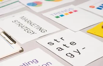 Unos documentos encima de la mesa donde se ven las palabras marketing y strategy