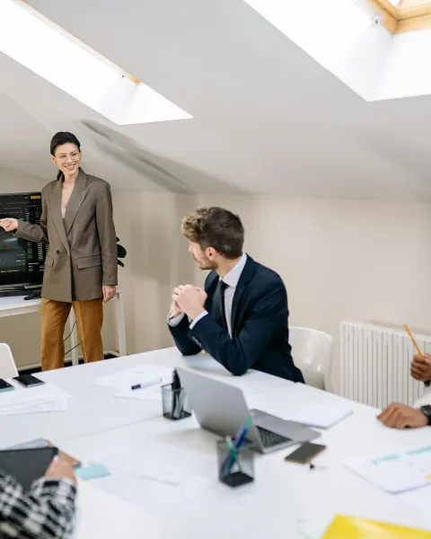 Sala donde se encuentran varias personas delante de una pantalla viendo gráficos sobre finanzas