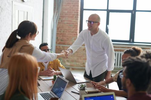 Un empresario hace un acuerdo con un cliente y le da la mano