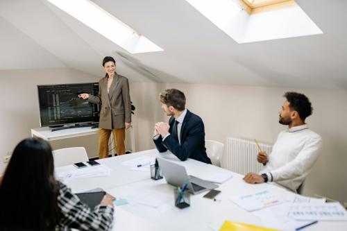 Sala donde se encuentran varias personas delante de una pantalla viendo gráficos sobre finanzas