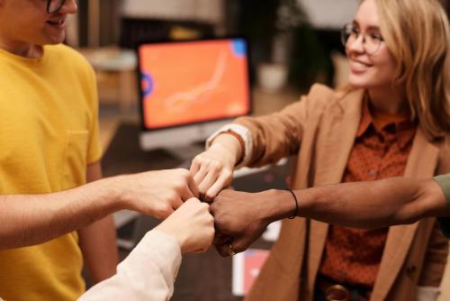 unos compañeros de trabajo chocan las manos 